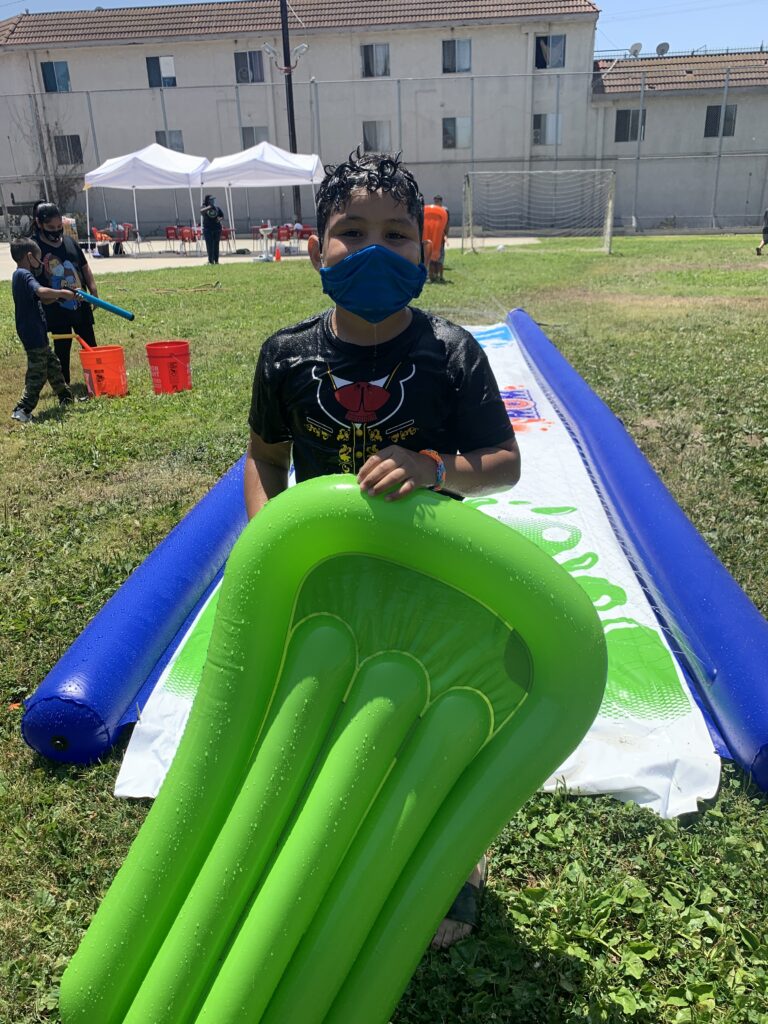 Young boy with air mattress at slip-n-slide