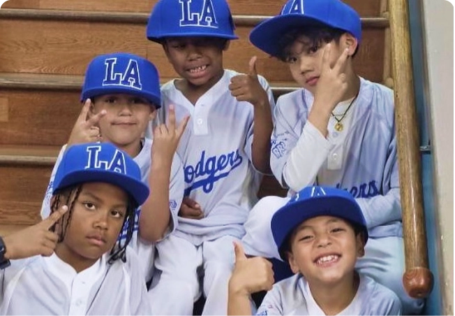 A group of boys in baseball uniforms in the Baseball Clinic at Los Angeles Boys and Girls Club