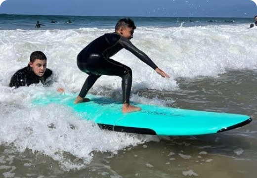 Boys having fun taking surf lessons at Los Angeles Boys and Girls Club summer camp